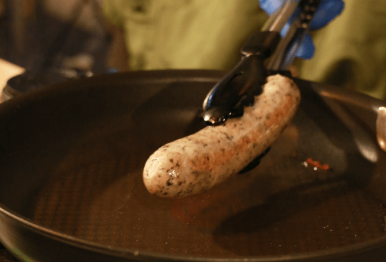 焼けたソーセージをトングで持ち上げる